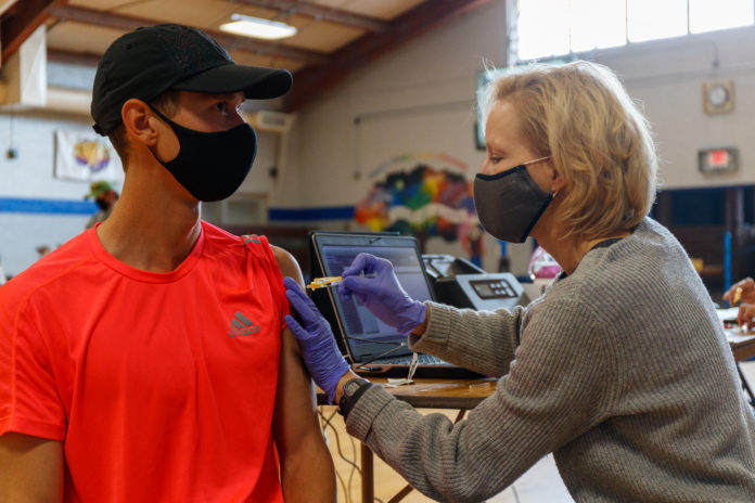 Nurse Dawn Barrowman inoculates Sam Prakel